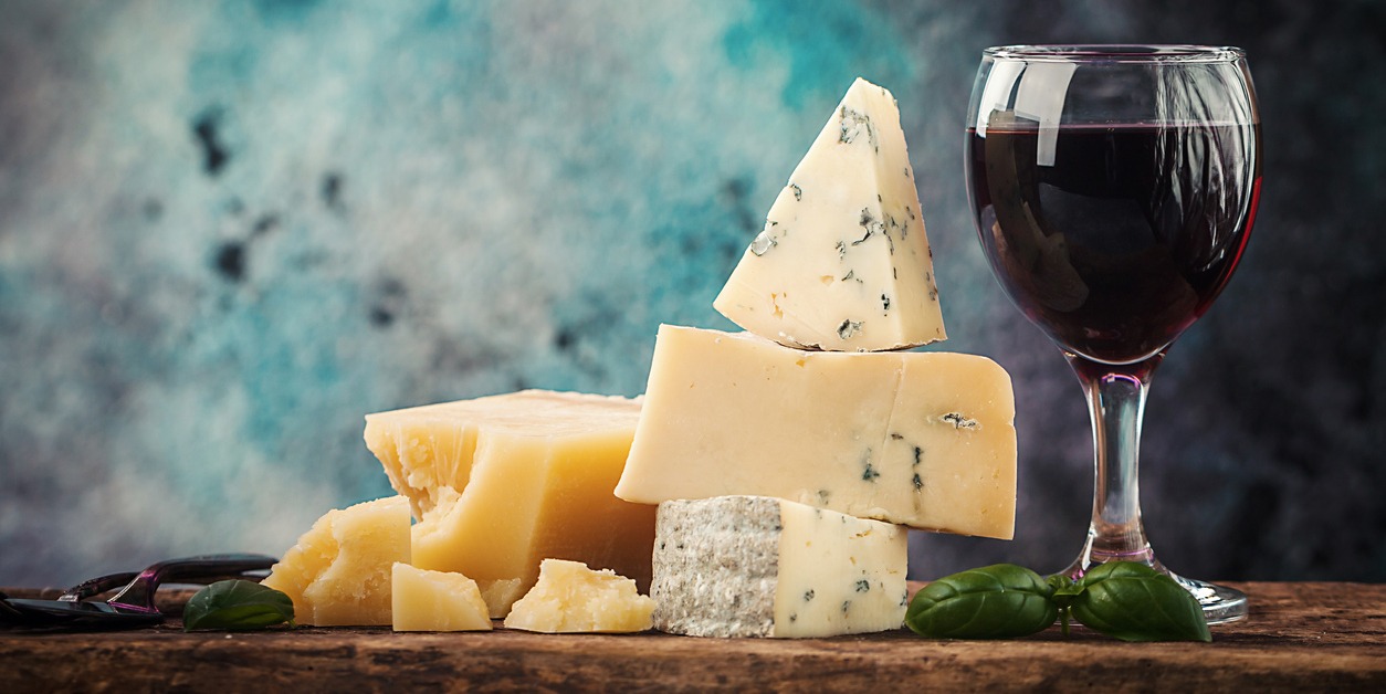 Various types of cheese and red wine still life on wooden table