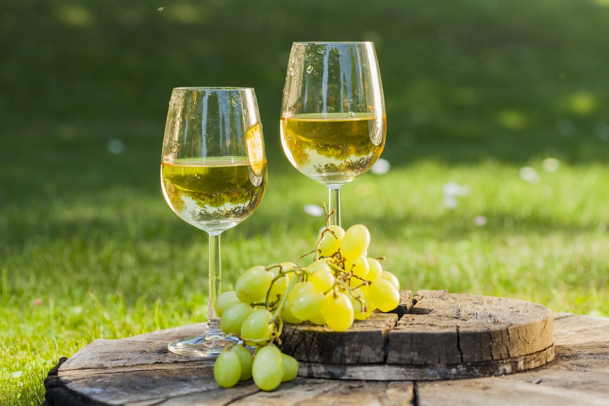 White wine with grapes on old wooden table