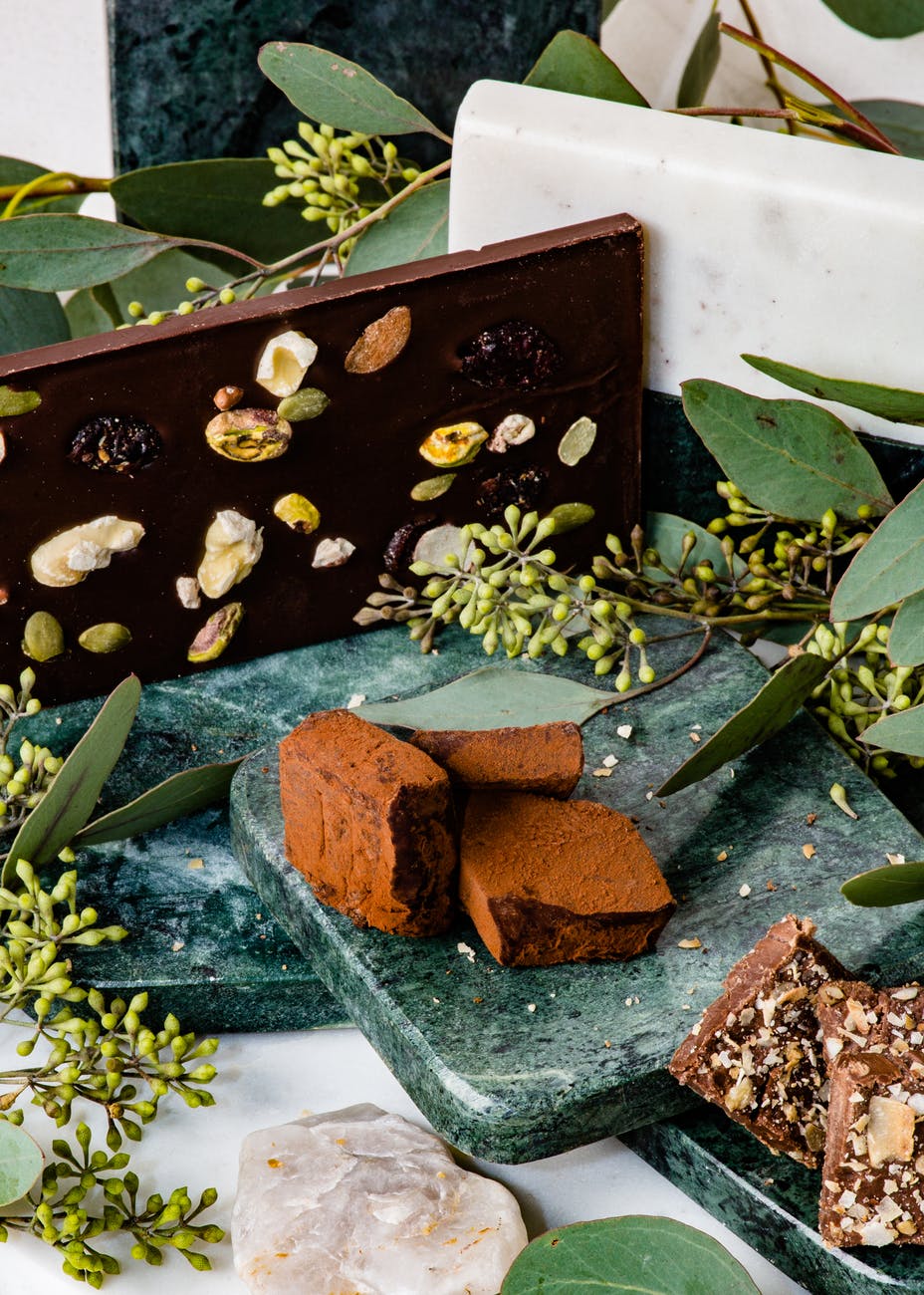 different chocolate bars on stones with decorative plants