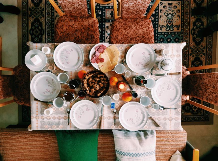 a high angle photography of a dinner set on the table surrounded with padded chairs