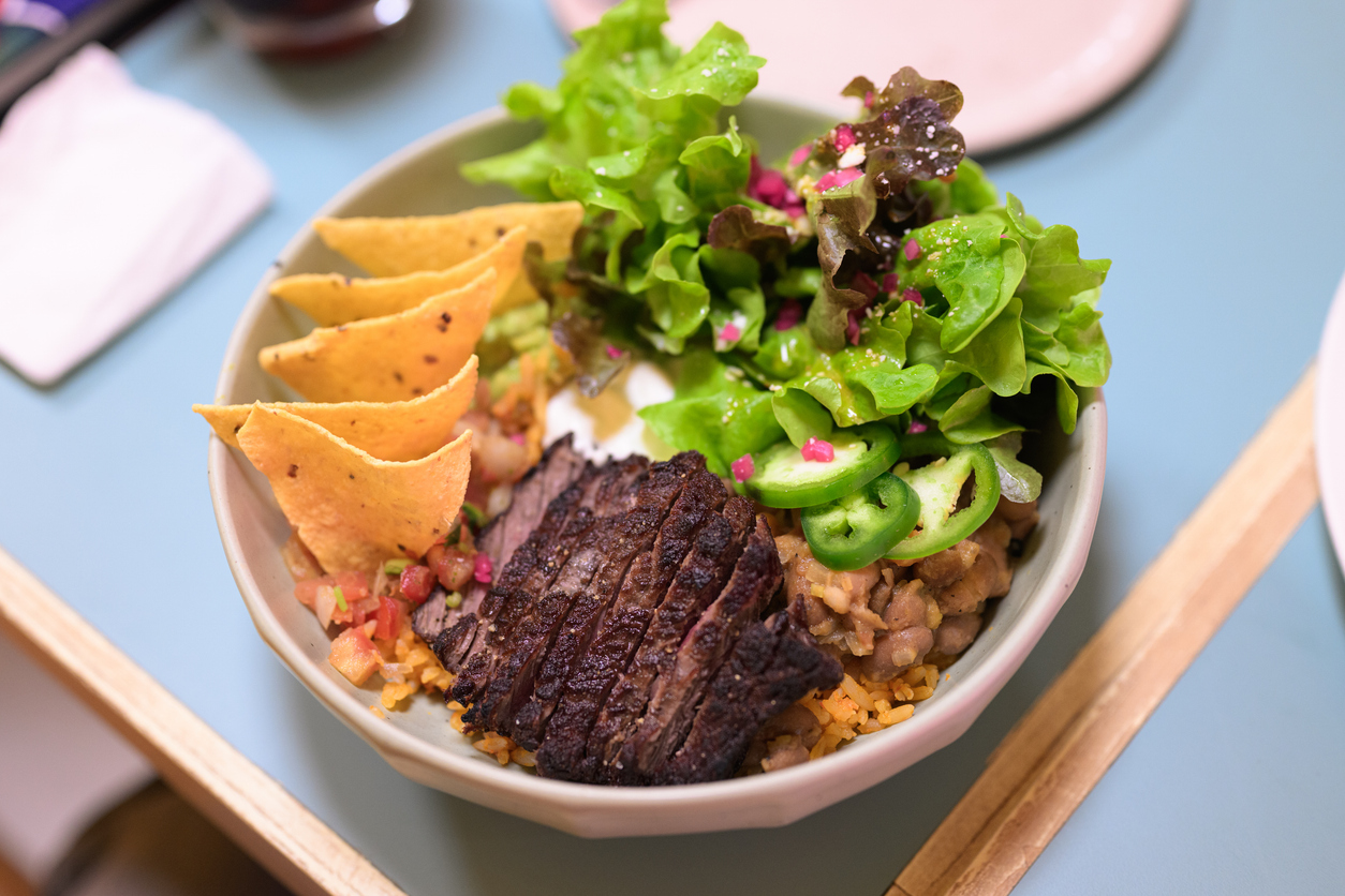 delicious grilled steak burrito bowl with rice, beans and fresh toppings
