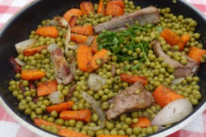 Lamb stew with peas carrot onion and aromatic plant in a cooking utensil