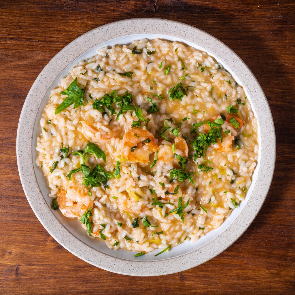 Risotto with shrimps in a plate, close-up, top view