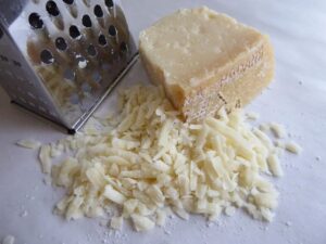 Image of grated parmesan cheese on a shelf.