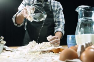 Picture of a Chef slowly adding water to flour to make the pasta dough.