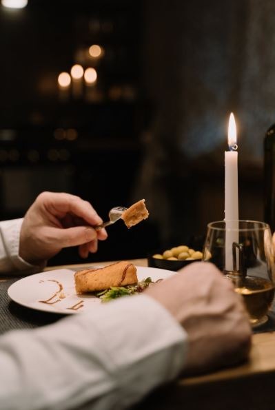 a person eating dinner with a candlelight